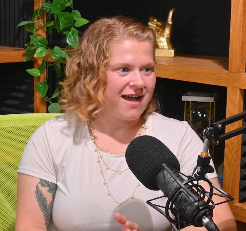 Aly Silver speaking into a podcast microphone in a studio